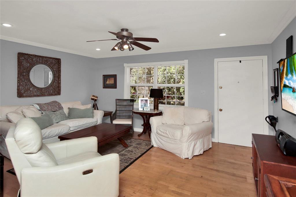 A living room features light gray walls, hardwood floors, white furniture, and a ceiling fan — 2500 LEE RD. UNIT 222, WINTER PARK, FL
