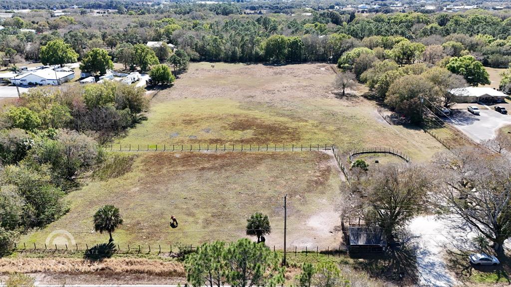 An aerial view shows a large, fenced grassy pasture with a small shed and trees — 448 NW 34TH STREET, OKEECHOBEE, FL