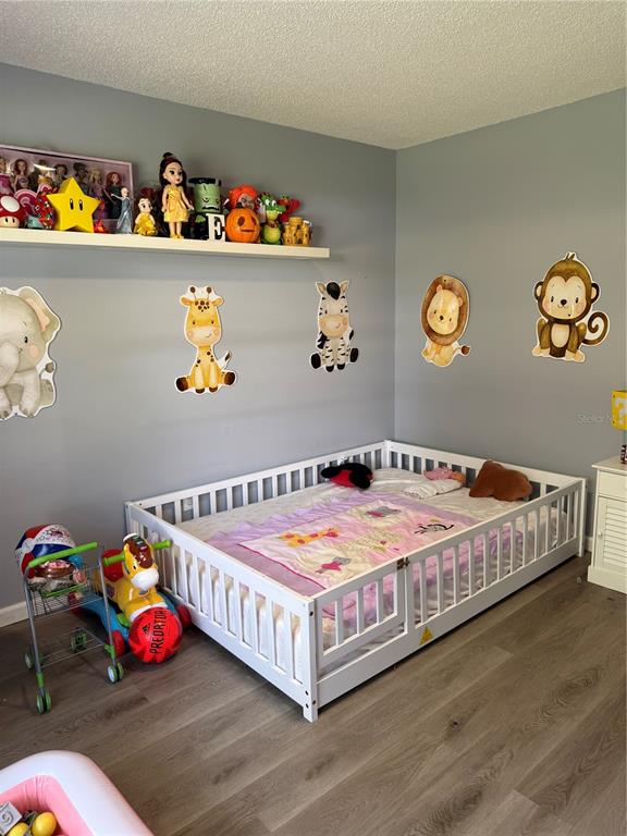 A child's bedroom features a floor-level bed with railings, wall decals, and a floating toy shelf — 217 CITRUS DR, KISSIMMEE, FL