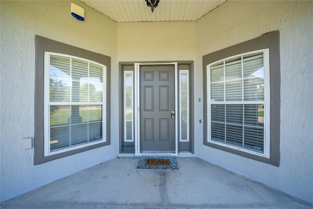 A front entryway features a gray door with sidelights flanked by two large windows — 198 MALAUKA RUN, OCKLAWAHA, FL