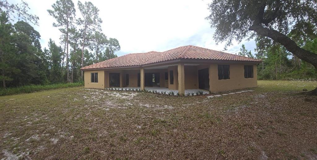 A single-story stucco house with a tile roof and arched windows sits on a lawn — 2051 LORENE LANE, DELTONA, FL