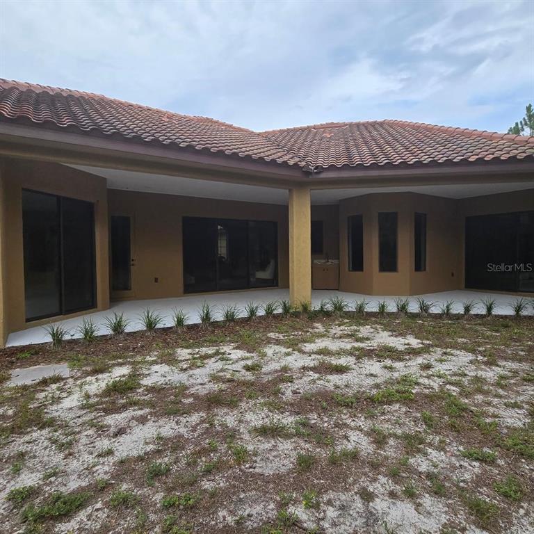 A tan, single-story stucco house with a tiled roof sits on a grassy lot — 2051 LORENE LANE, DELTONA, FL