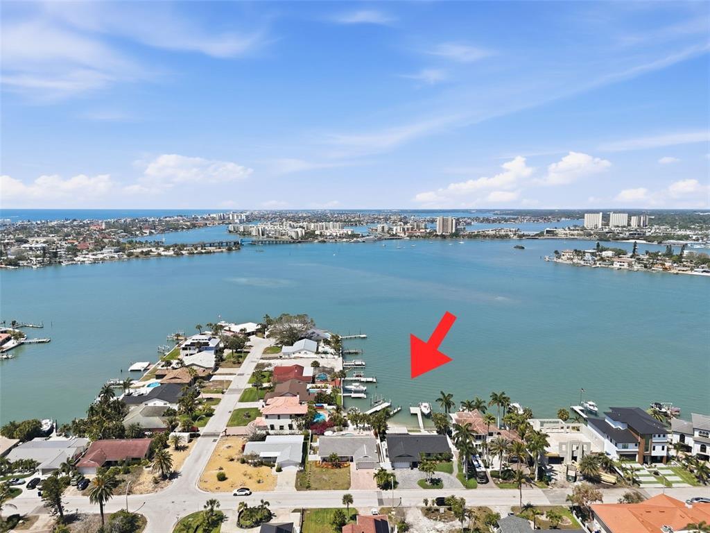 An aerial view shows a waterfront house with a private dock on a bay — 711 64TH AVENUE, ST PETE BEACH, FL