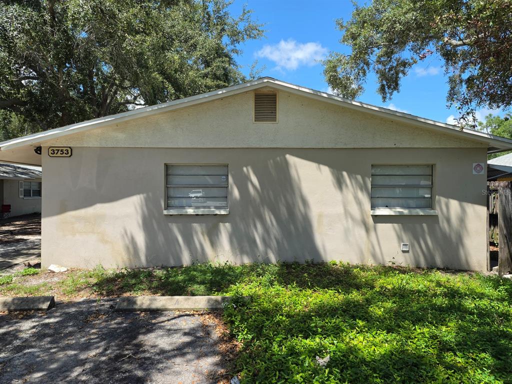 The exterior of a single-story stucco building features two louvered windows and a gable roof — 3753 141ST PLACE, LARGO, FL