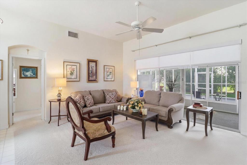 A living room with beige sofas, a wooden coffee table, and large sliding glass doors — 168 W ROMANY LOOP, BEVERLY HILLS, FL