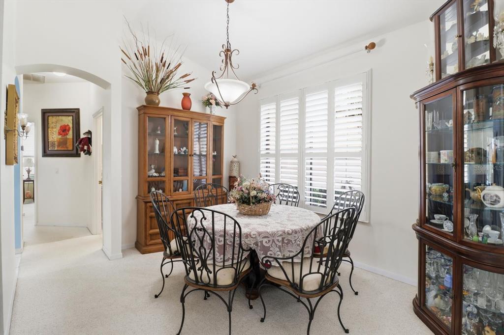 A dining room features a round table, wrought iron chairs, and two wooden china cabinets — 168 W ROMANY LOOP, BEVERLY HILLS, FL