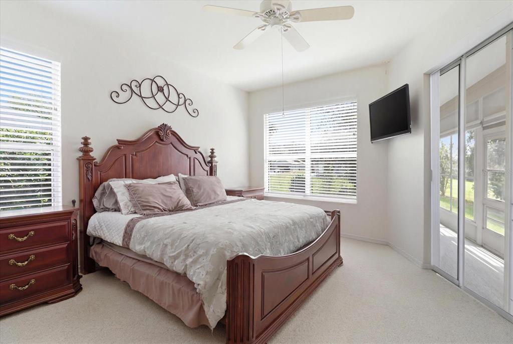 A bedroom features a wooden bed frame, a ceiling fan, and sliding glass doors — 168 W ROMANY LOOP, BEVERLY HILLS, FL