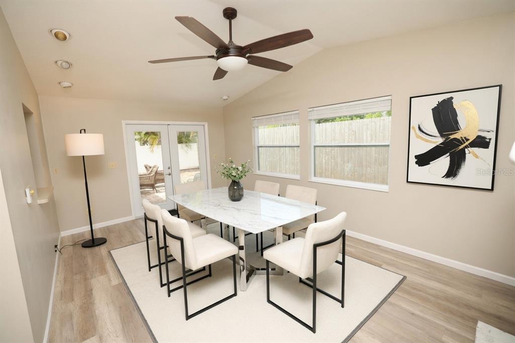 A dining room with a marble table, six chairs, a ceiling fan, and wall art — 5864 MARIGOLD ROAD, VENICE, FL