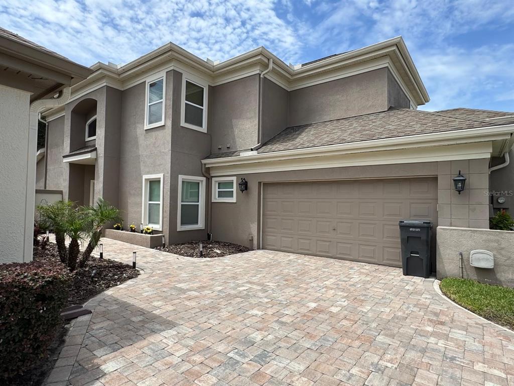 A two-story house with a beige stucco exterior, a paved driveway, and an attached garage — 5121 FAIRWAY ONE DRIVE, VALRICO, FL