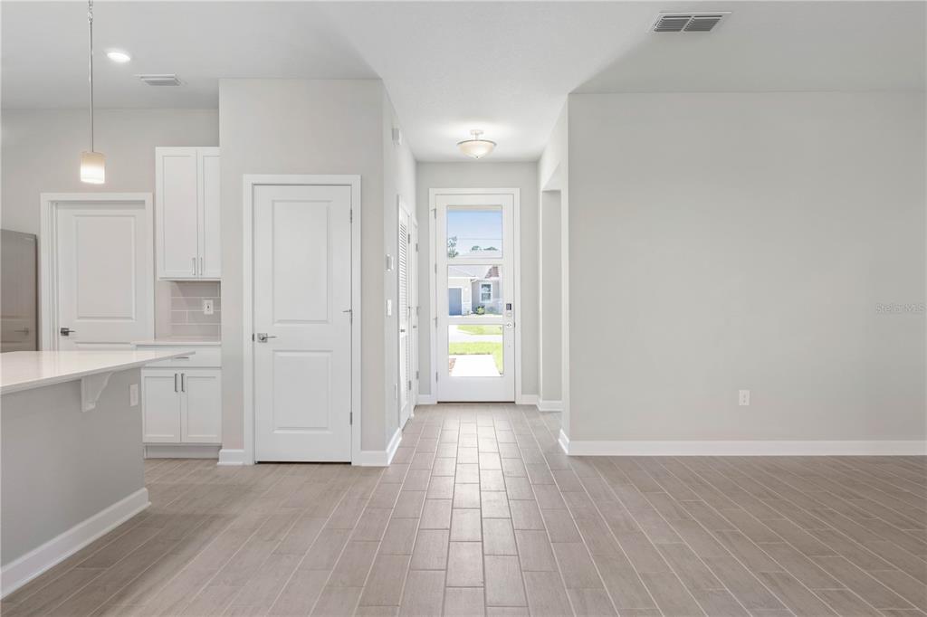 A bright entryway features light wood-look tile flooring, white walls, and a glass-paneled front door — 3162 FERGUS STREET, NORTH PORT, FL