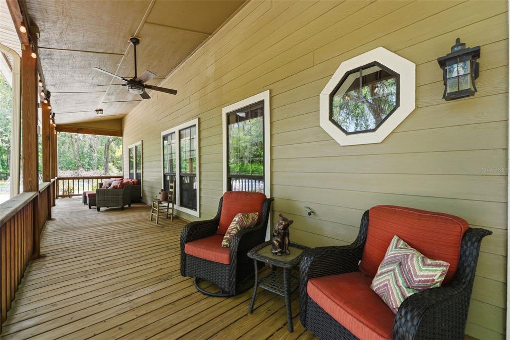 A wooden porch with string lights overlooks a brick walkway and a grassy backyard — 381 N JUNGLE ROAD, GENEVA, FL