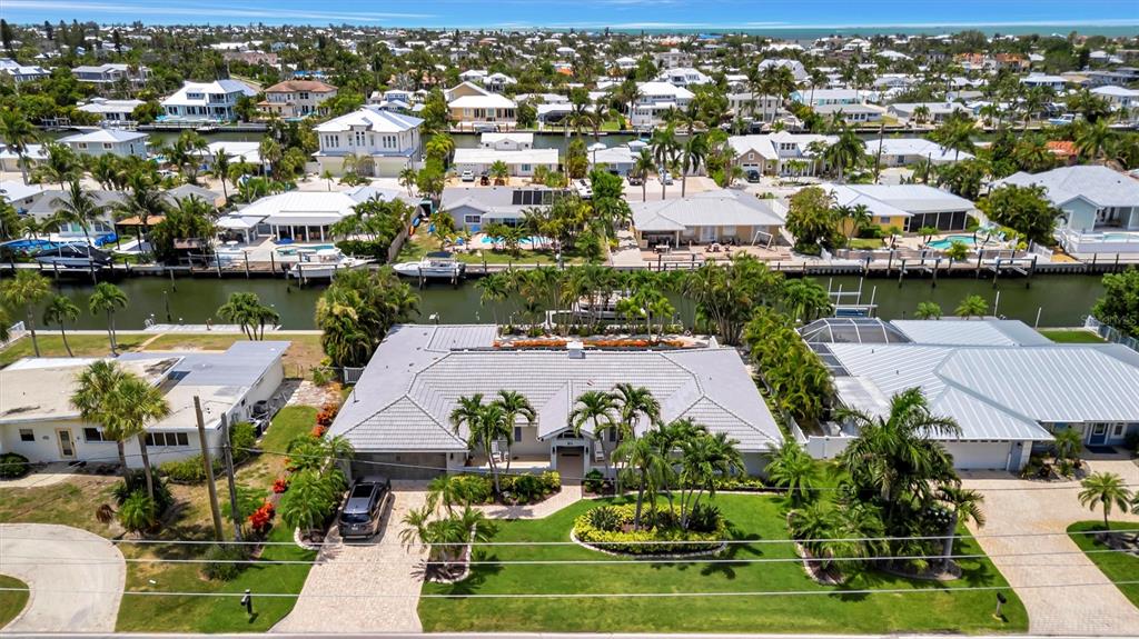 An aerial view shows a residential waterfront property with a canal and surrounding houses — 514 KEY ROYALE DRIVE, HOLMES BEACH, FL