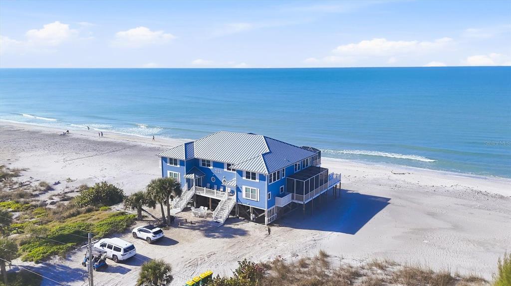 An aerial view of a blue two-story house situated directly on a sandy beach — 221 N GULF BOULEVARD UNIT A, PLACIDA, FL