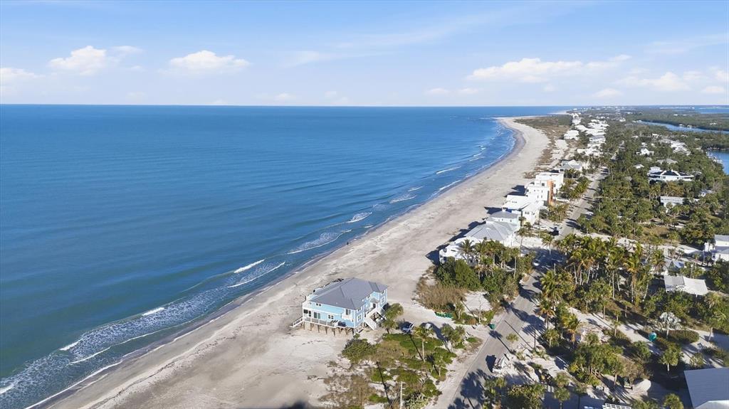 An aerial view shows a beach house on a sandy shore along the ocean — 221 N GULF BOULEVARD UNIT A, PLACIDA, FL