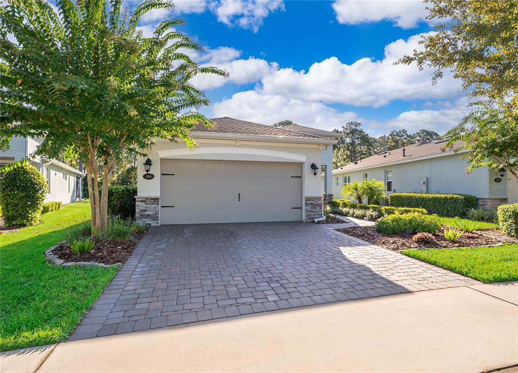 A single-story house with a two-car garage, stone accents, and a paved driveway — 1309 HAYTON AVENUE, DELAND, FL