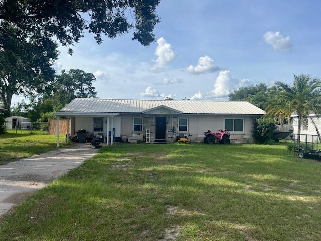 A single-story house with a metal roof, a carport, and a large front yard — 400 E POMELO STREET, LAKE ALFRED, FL