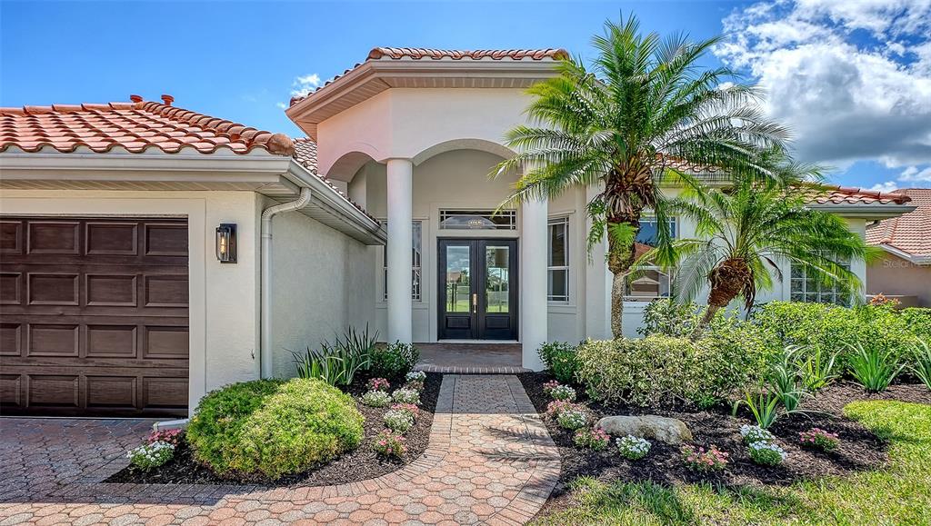 A bright entryway features light wood floors, a coffered ceiling, and black double front doors — 2729 HARVEST DRIVE, SARASOTA, FL