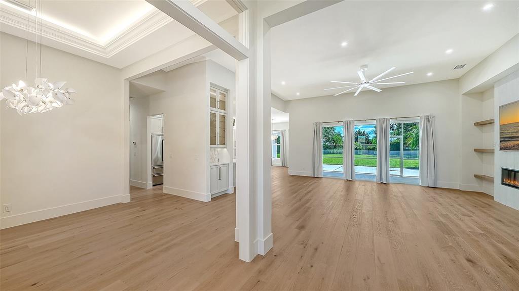 A bright entryway features a coffered ceiling with white shiplap, a crystal chandelier, and transom windows — 2729 HARVEST DRIVE, SARASOTA, FL