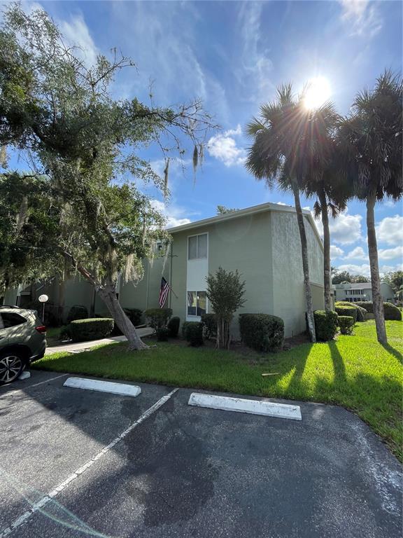 A two-story light green apartment building with a parking lot and palm trees — 586 BAHIA CIRCLE UNIT B, OCALA, FL