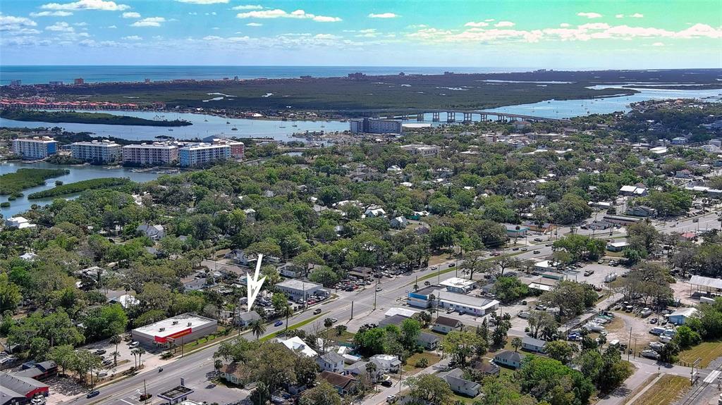 An aerial view shows a small house marked by an arrow near a commercial road — 607 N DIXIE FREEWAY, NEW SMYRNA BEACH, FL