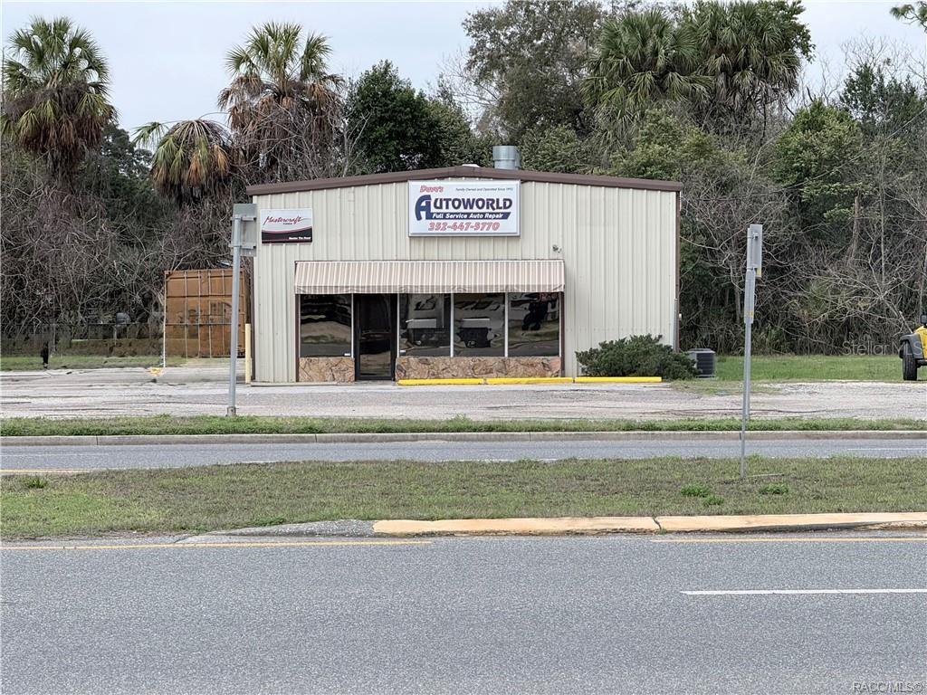 A single-story commercial building with a metal exterior and a striped awning over the entrance — 8 HIGHWAY 19 N, INGLIS, FL