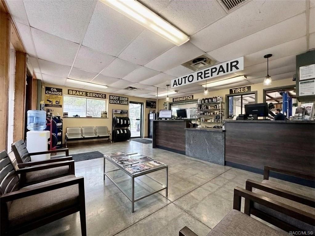 A waiting area in an auto repair shop features chairs, a coffee table, and service counters — 8 HIGHWAY 19 N, INGLIS, FL