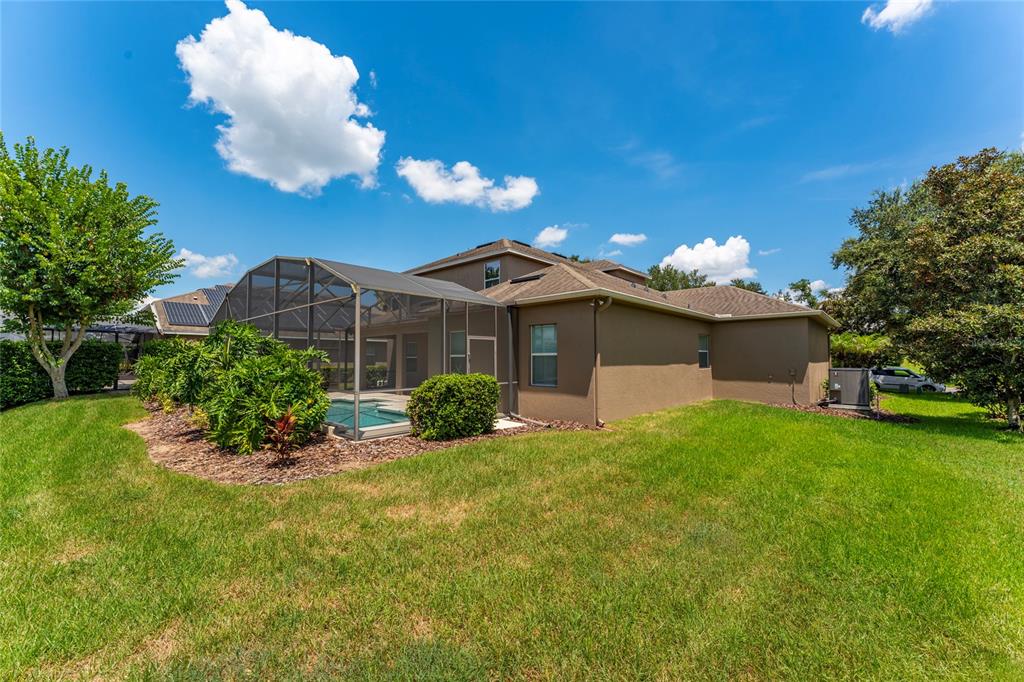 A two-story house features a screened-in patio and pool area in the backyard — 2202 REDMARK LANE, WINTER GARDEN, FL