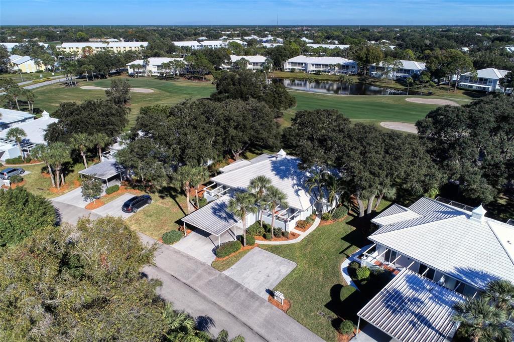 An aerial view shows a single-story house with a metal roof and a carport — 216 CERROMAR WAY S UNIT 30, VENICE, FL