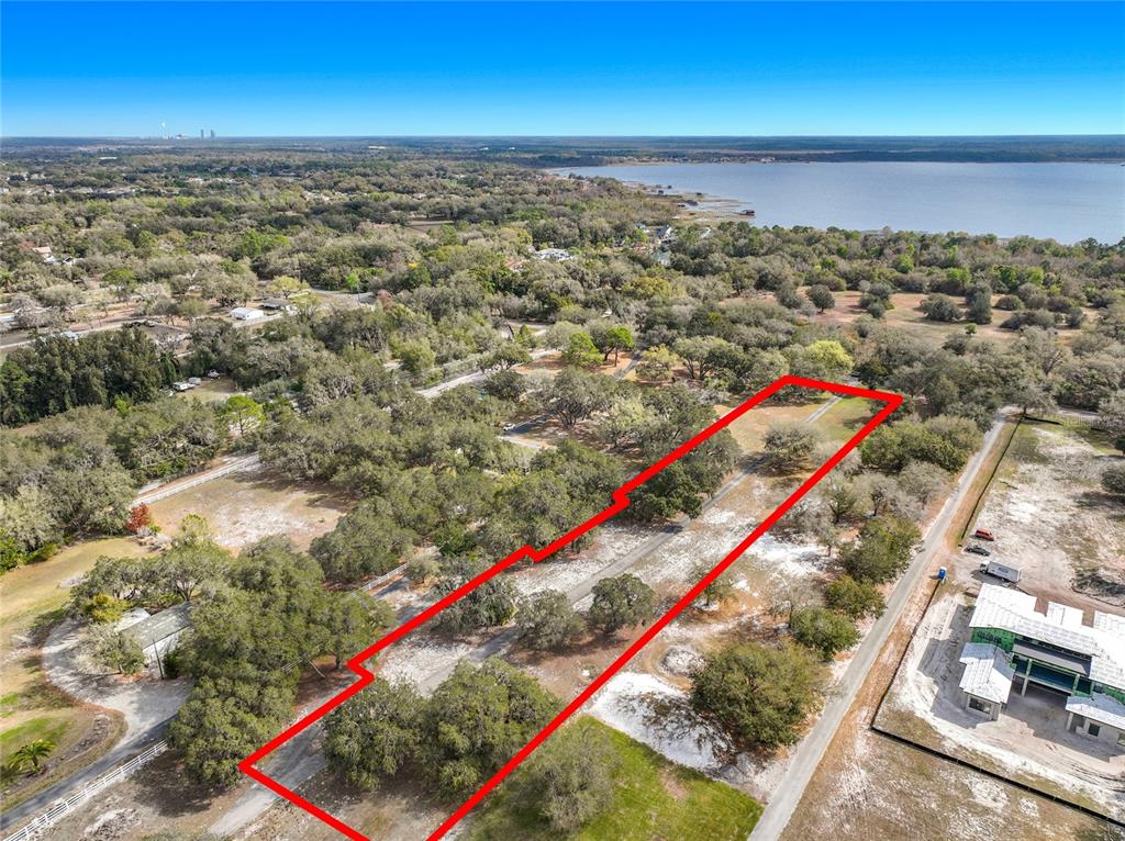 An aerial view shows a rectangular plot of land outlined in red near a lake — KIRBY SMITH ROAD, ORLANDO, FL