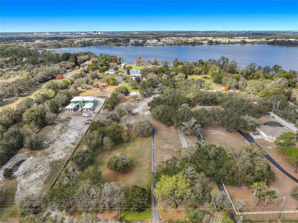 An aerial view shows a large, wooded residential lot with a house under construction — KIRBY SMITH ROAD, ORLANDO, FL