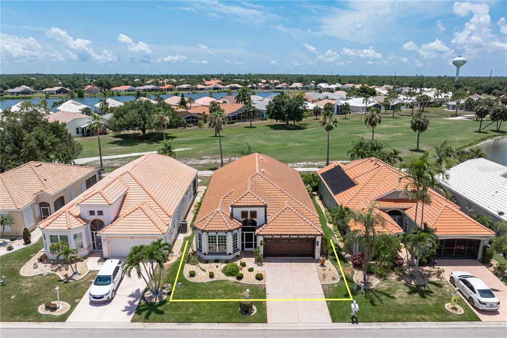 An aerial view shows a single-story house with a tiled roof and a front driveway — 10309 WINDSONG ROAD, PUNTA GORDA, FL