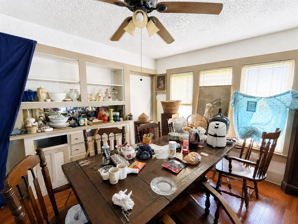 A dining room features a wooden table, built-in shelving, and a ceiling fan — 202 SHADY PLACE, DAYTONA BEACH, FL