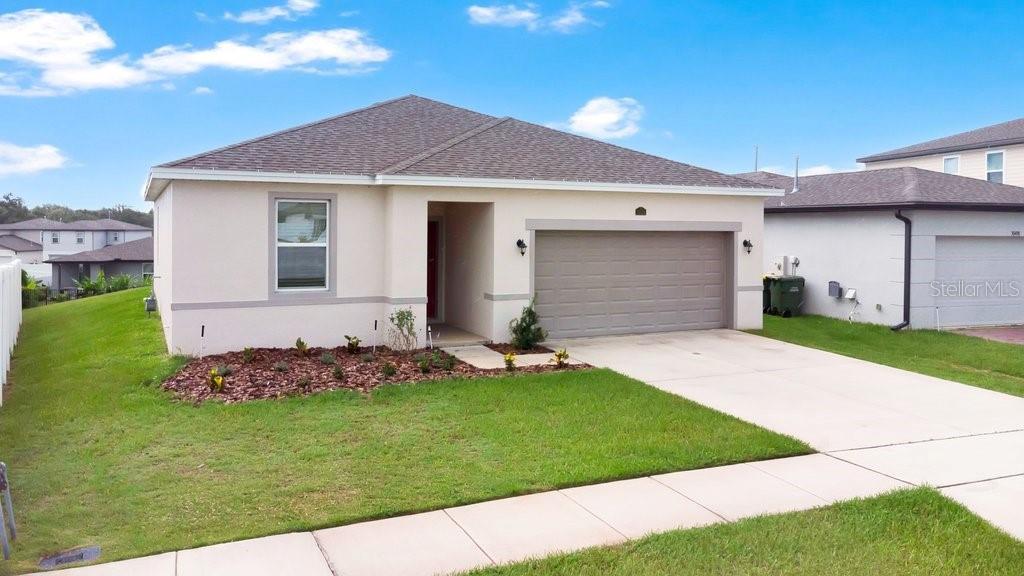 A single-story house with a beige exterior, a two-car garage, and a front lawn — 30502 PINTAIL DRIVE, LEESBURG, FL