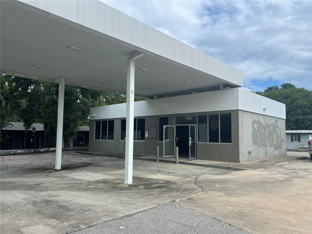 A vacant commercial building with a large canopy and a concrete parking area — 1327 E SILVER SPRINGS BOULEVARD, OCALA, FL