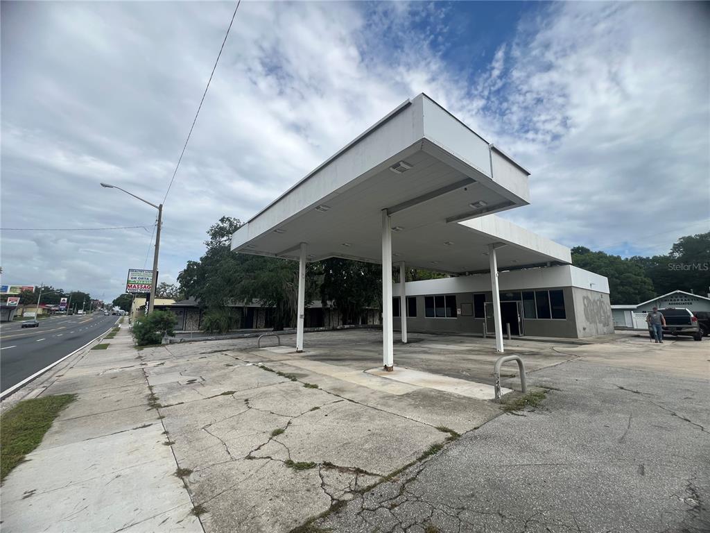 An exterior view of a vacant, single-story commercial building with a large, flat-roofed canopy — 1327 E SILVER SPRINGS BOULEVARD, OCALA, FL