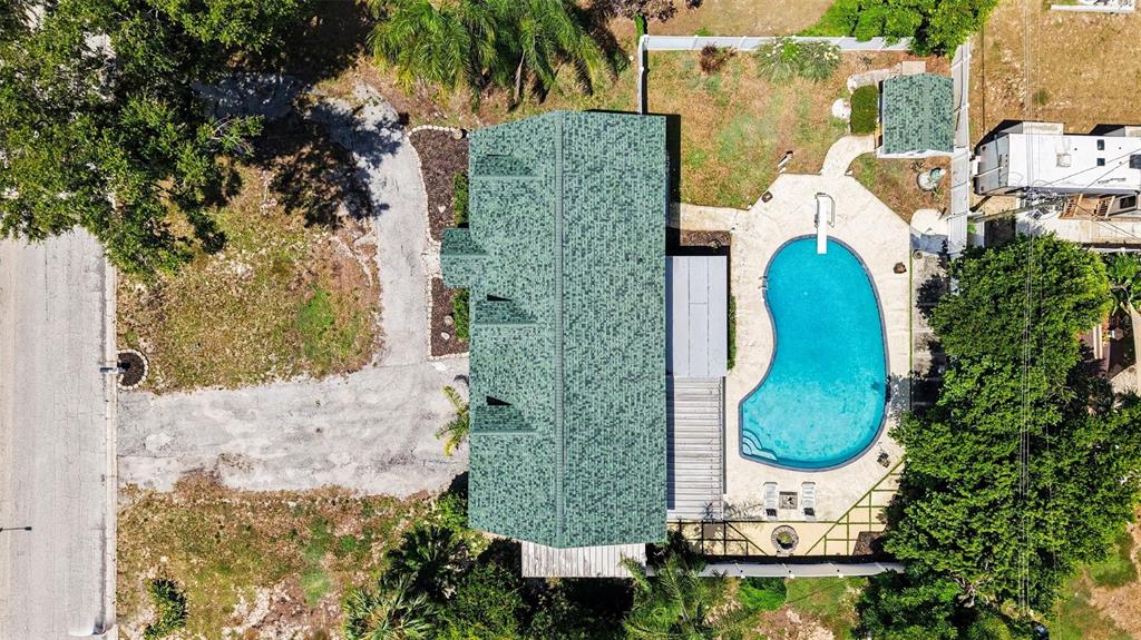 An aerial view shows a house with a green roof, a pool, and a driveway — 404 CLARISSA DRIVE, BRANDON, FL