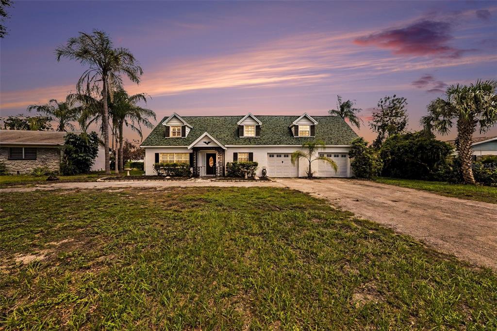 A single-story house with a green roof, white siding, and a large front yard — 404 CLARISSA DRIVE, BRANDON, FL