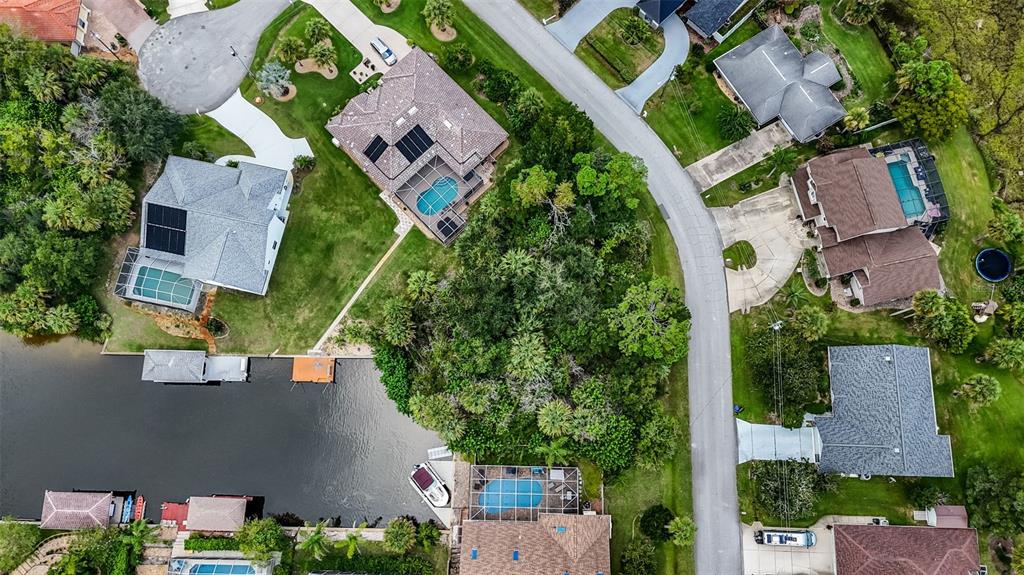Aerial view of several suburban houses with swimming pools and docks along a canal — 15 COVINGTON LANE, PALM COAST, FL