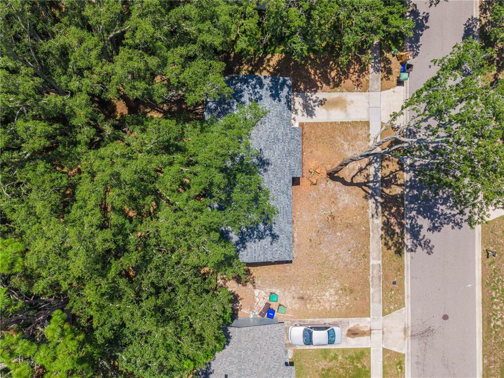 An aerial view shows a house with a gray roof surrounded by many large trees — 3669 YOSEMITE DRIVE, ORLANDO, FL