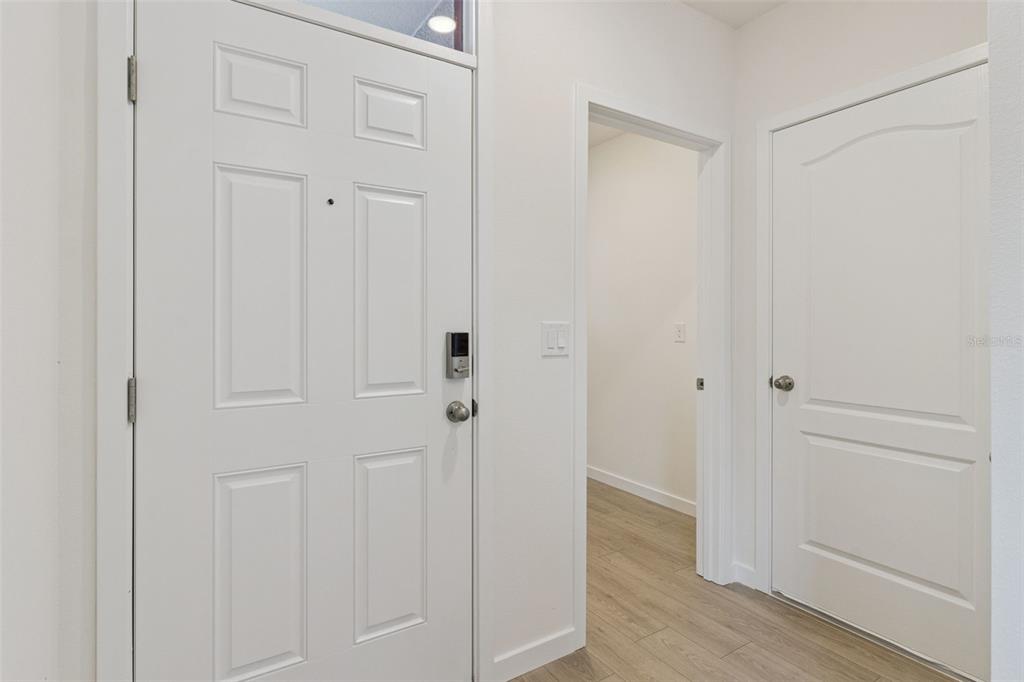 An entryway features a white front door, a doorway to another room, and a closet door — 1347 GRAND FLORA LANE, SANFORD, FL