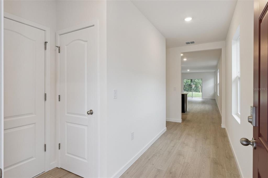 A bright entryway with light wood-look flooring leads into an open-concept living area — 1347 GRAND FLORA LANE, SANFORD, FL