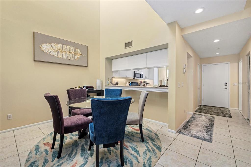 A dining area with a glass table, four chairs, and a pass-through to the kitchen — 2012 HARBOURSIDE DRIVE UNIT 2102, LONGBOAT KEY, FL