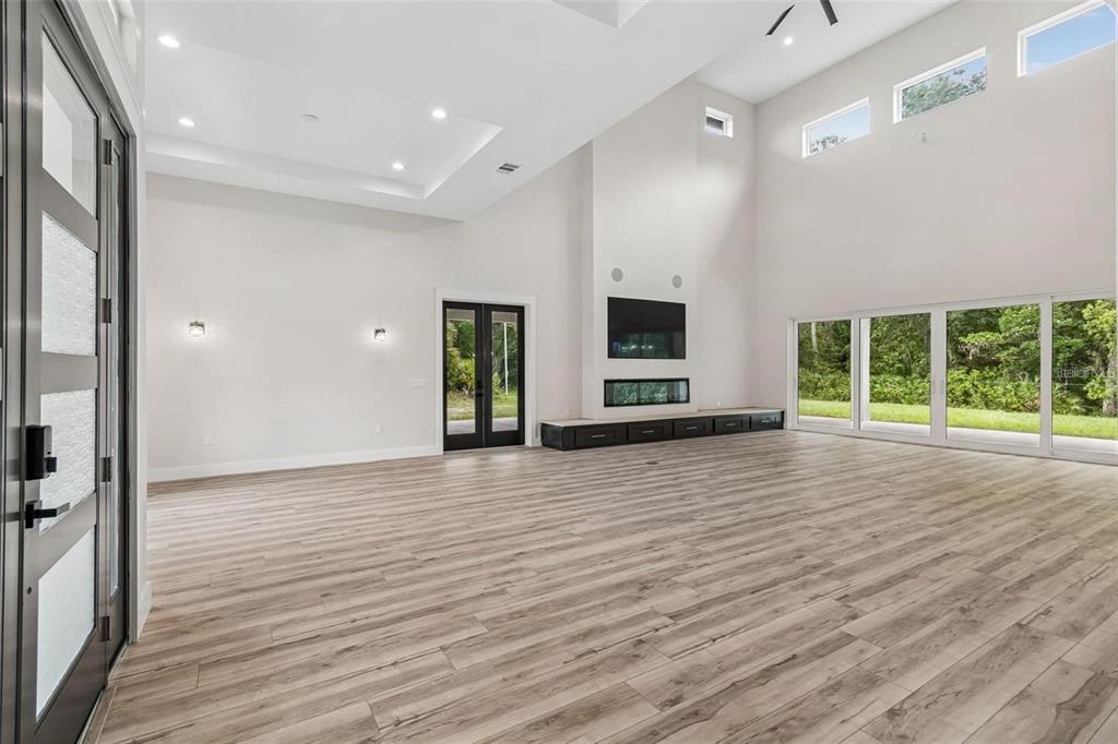 A covered front porch features a dark double door, a chandelier, and large windows — 12000 GOLDEN VALLEY DRIVE, NEW PORT RICHEY, FL