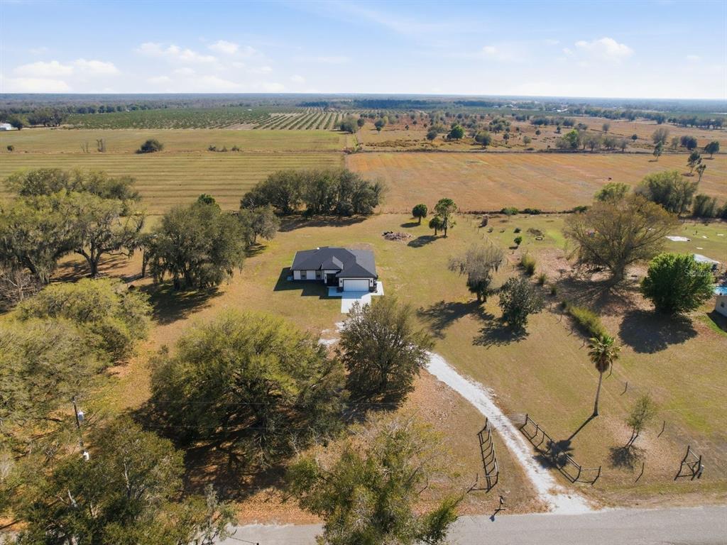 An aerial view shows a single-story house situated on a large, grassy rural lot — 4135 SW LANGFORD STREET, ARCADIA, FL
