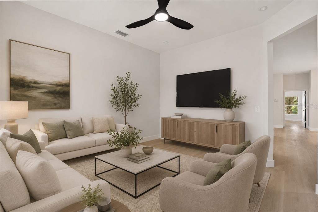 A living room features a white sofa, two armchairs, a television, and a ceiling fan — 823 E MCDONALD AVENUE, EUSTIS, FL