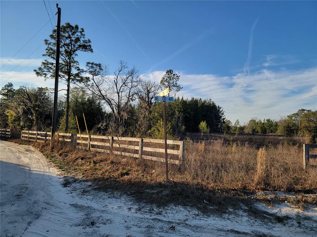 A dirt road leads to a vacant, fenced lot at a street corner — 0 NE 20TH STREET, WILLISTON, FL