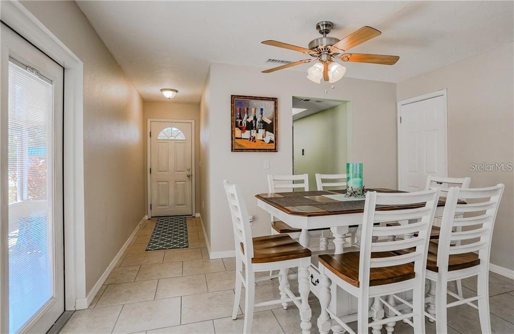 A dining area with a white table and chairs, tile flooring, and a ceiling fan — 2907 HYDE PARK STREET, SARASOTA, FL