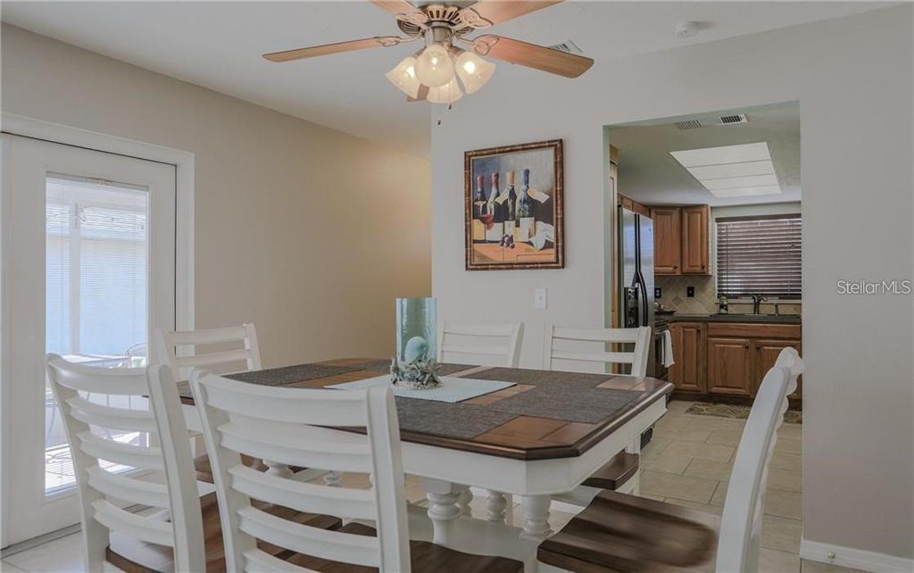 A dining area with a white table and chairs sits in front of a kitchen — 2907 HYDE PARK STREET, SARASOTA, FL