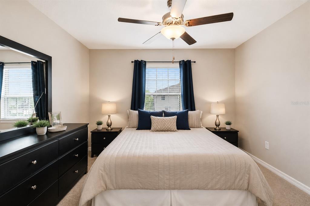 A bedroom features a queen bed, two nightstands with lamps, and a black dresser — 633 ROYAL EMPRESS DRIVE, RUSKIN, FL