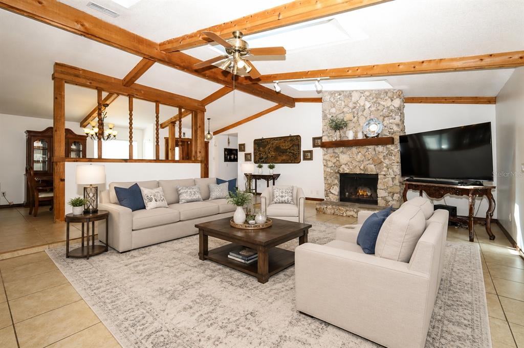 A living room features a stone fireplace, exposed wooden ceiling beams, and a light-colored sofa — 1534 PEREZ STREET, ORLANDO, FL